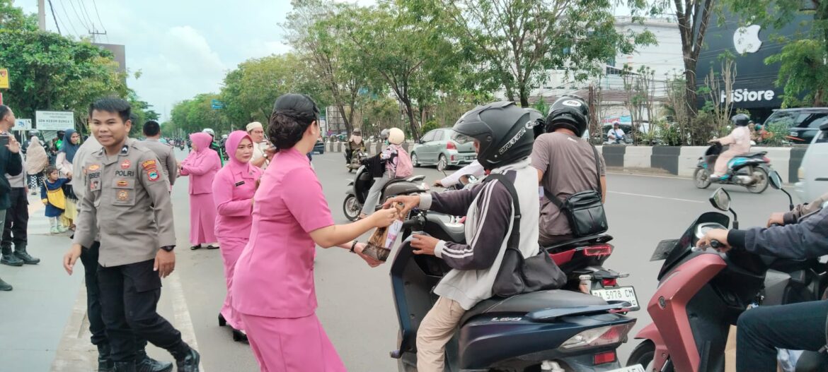 BAGI TAKJIL - Ibu-ibu Bhayangkari yang tergabung dalam Polsek Banjarmasin Timur saat membagikan Takjil kepada pengendara yang melintas di depan Mapolsek setempat Jalan A Yani Km 4,5 Bantim, Selasa (10/3/2026). (foto:sum/brt).
