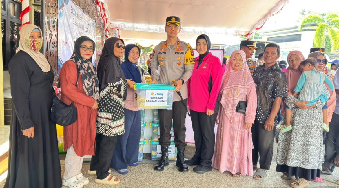 Kapolres Tabalong AKBP Wahyu Ismoyo J., S.I.K., M.H., M.Tr.Opsla didampingi Ketua Bhayangkari Cabang Tabalong Ny. Vio Ismoyo menyerahkan paket sembako kepada pengunjung pada kegiatan Gerakan Pangan Murah di halaman Polres Tabalong, Jumat (12/3). (foto: istimewa)