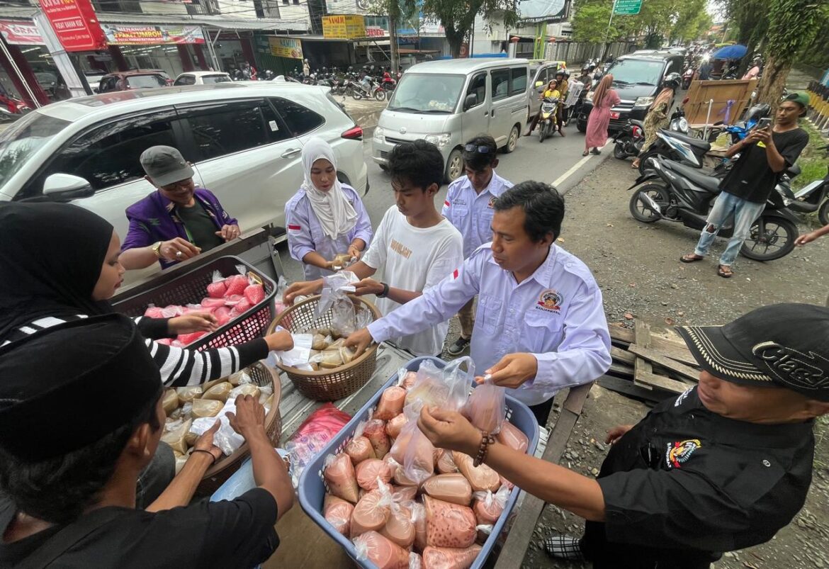 Anggota Jaga Mbojo Banjarmasin Bersaudara (JMB) membagikan paket takjil kepada pengendara yang melintas di kawasan Taman Kamboja Banjarmasin, Minggu (15/3/2026). (foto: Iman Satria)