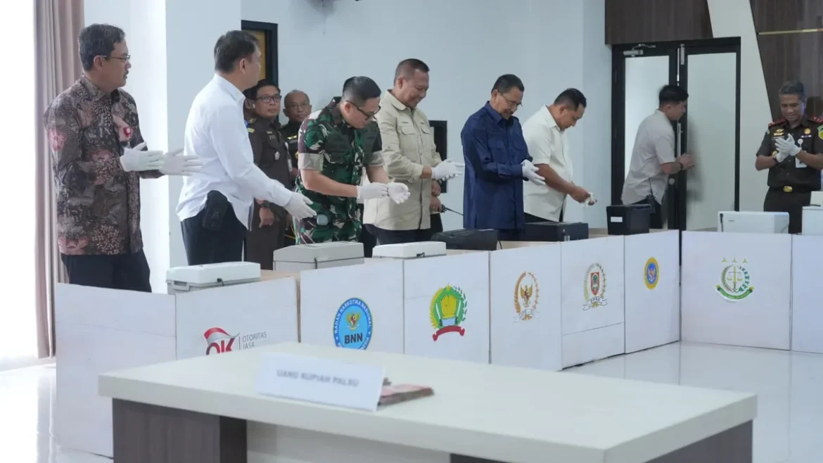 UANG PALSU-Ketua DPRD Provinsi Kalsel Dr (HC) H Supian HK, SH, MH (baju biru) saat menghadiri pemusnahan barang bukti uang rupiah palsu di Mako BINDA Kalsel di Banjarbaru.(foto : humasdprdkalsel)