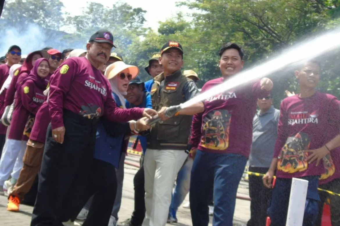 Wali Kota Banjarmasin, HM Yamin beraksi menyemprotkan air melalui selang pemadam.
