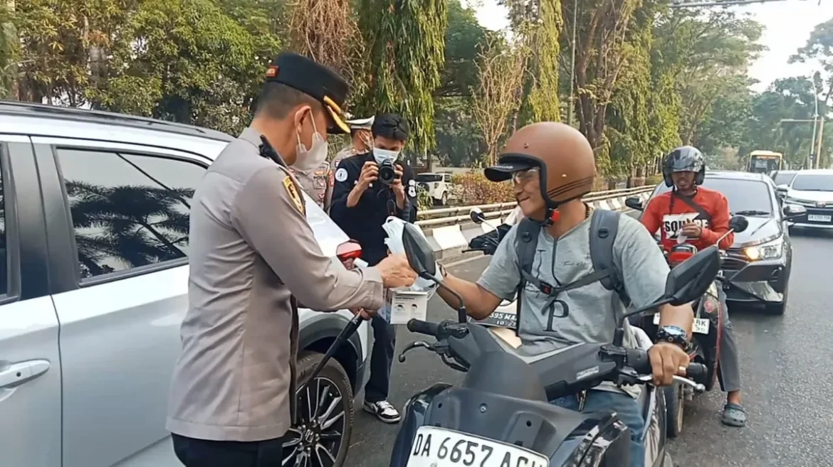 BAGI MASKER - Kapolresta Banjarmasin Kombes Pol Riza Muttaqin memimpin langsung pembagian masker tersebut di kawasan lampu merah Simpang Empat Masjid Raya Sabilal Muntadin, Senin (31/8/2026) pagi. (foto:istimewa)