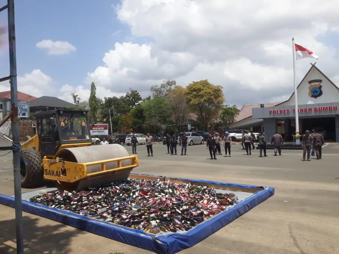 MIRAS DIMUSNAHKAN - Ribuan botol minuman keras ilegal dimusnahkan dengan cara dilindas alat berat di halaman Mapolres Tanah Bumbu, Kamis (3/9/2026). (foto:istimewa)