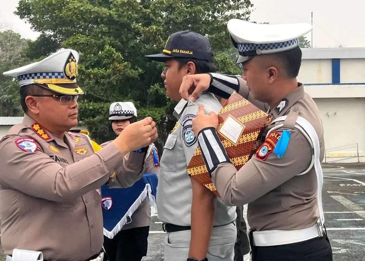 OPERASI PATUH INTAN 2026 : Dirlantas Polda Kalsel Kombes Pol Fahri Siregar menyematkan pita operasi kepada perwakilan petugas dalam apel gelar Operasi Patuh Intan 2026 di Banjarmasin, Senin (26/10/2026). (foto: Iman Satria)
